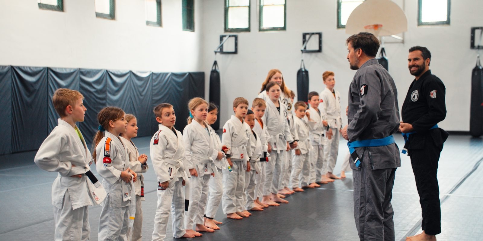 Children in gi lined up with their instructors at Crossroads Martial Arts